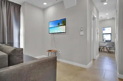 a living room with a couch and a tv on a wall at Miami Flats - Self Check-in and 1 Free Parking in Miami
