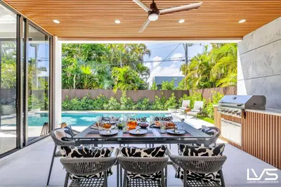 an outdoor dining area with a table and chairs at Villa Enclave- Brand New Luxe Las Olas Beach Villa in Fort Lauderdale