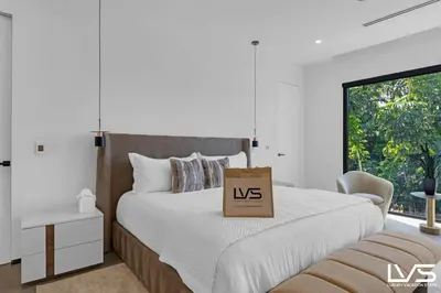 a white bedroom with a us sign on a bed at Villa Enclave- Brand New Luxe Las Olas Beach Villa in Fort Lauderdale