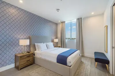 a bedroom with a bed and a blue and white wall at 2BR Modernos South Beach | 5 min da praia in Miami Beach