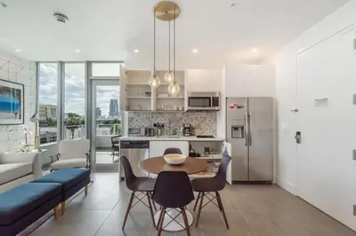 a kitchen and living room with a table and chairs at 2BR Modernos South Beach | 5 min da praia in Miami Beach