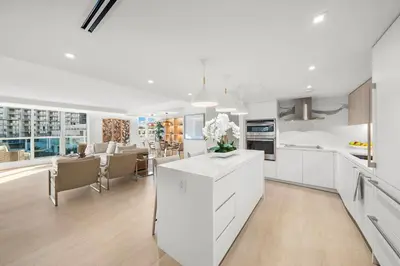 a kitchen with white cabinets and a dining room at 1 Bedroom Private Residence at Roney Palace - 607 in Miami Beach