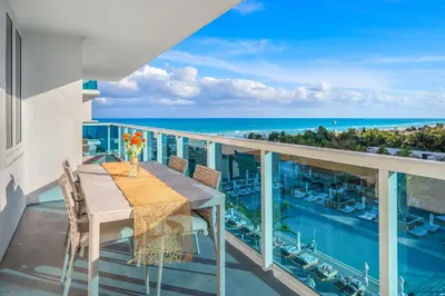 a balcony with a table and chairs and the ocean at 2 Bedroom Private Residence at Roney Palace -6072B in Miami Beach