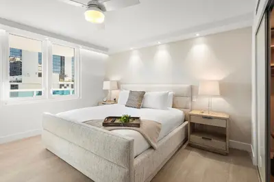 a white bedroom with a bed and a chair at 1 Bedroom Plus Den Private Residence at Roney Palace -608 in Miami Beach