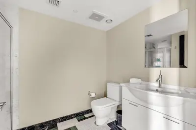 a white bathroom with a toilet and a sink at Stunning Apartment at Icon with Bay Views-Pool-Gym-Spa in Miami