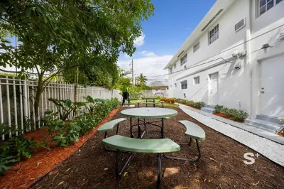 a table and chairs in the courtyard of a building at Modern Studio - Gym & Parking Close to Aventura in Miami