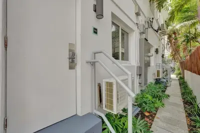 a white house with a white door and stairs at NEW Studio at Eden Collection Steps to Beach 1106 in Fort Lauderdale