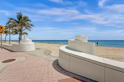 a sandy beach with palm trees and the ocean at Eden Collection Studio Steps to Beach in Fort Lauderdale