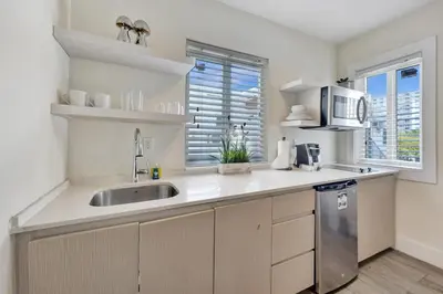 a kitchen with a sink and a microwave at Eden Collection Studio Steps to Beach in Fort Lauderdale