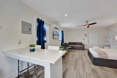a white living room with a bed and a couch at Eden Collection Studio Steps to Beach in Fort Lauderdale