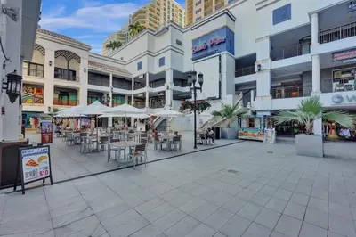 an empty shopping mall with tables and chairs and buildings at Eden Collection Studio Steps to Beach in Fort Lauderdale