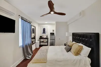 a bedroom with a large bed and a ceiling fan at Eden Collection Studio Steps to Beach in Fort Lauderdale