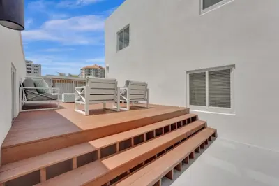 a balcony with two chairs and a wooden deck at 2102 Eden Collection 1BR Kitchen Steps to beach in Fort Lauderdale