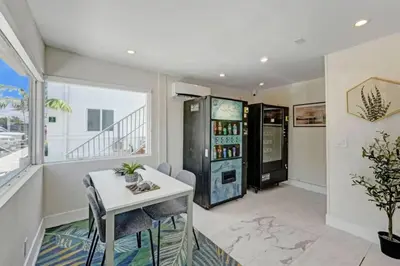a dining room with a table and a refrigerator at 2102 Eden Collection 1BR Kitchen Steps to beach in Fort Lauderdale