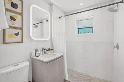 a white bathroom with a sink and a mirror at 2102 Eden Collection 1BR Kitchen Steps to beach in Fort Lauderdale