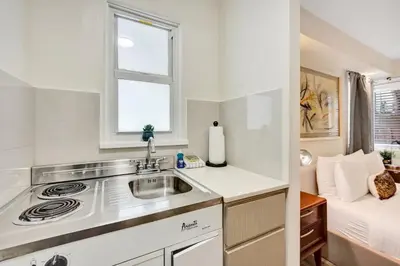 a kitchen with a sink and a window and a bed at Eden Escape Walk to FLT Beach 1104 in Fort Lauderdale