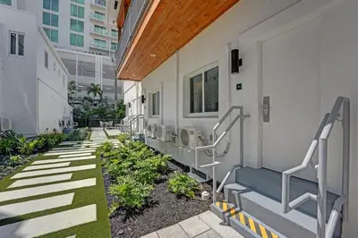 a corridor of a building with stairs and plants at Eden Escape Walk to FLT Beach 2105 in Fort Lauderdale