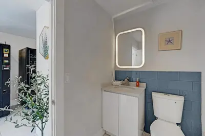a bathroom with a toilet and a sink and a mirror at Eden Escape Walk to FLT Beach 1202 in Fort Lauderdale