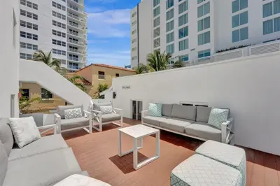 a patio with couches and a table and some buildings at Eden Escape Walk to FLT Beach 1103 in Fort Lauderdale