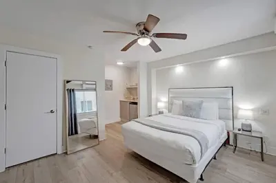 a white bedroom with a bed and a ceiling fan at Eden Escape Walk to FLT Beach 1102 in Fort Lauderdale