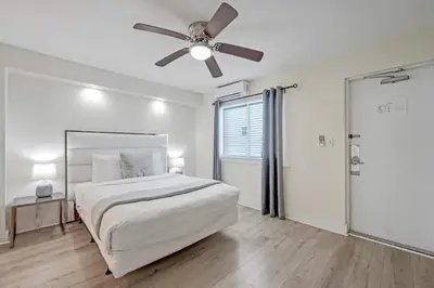 a white bedroom with a bed and a ceiling fan at Eden Escape Walk to FLT Beach 1102 in Fort Lauderdale