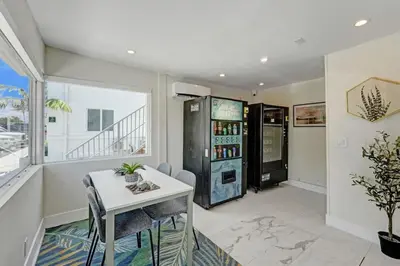 a dining room with a table and a refrigerator at Eden Escape Walk to FLT Beach 1102 in Fort Lauderdale