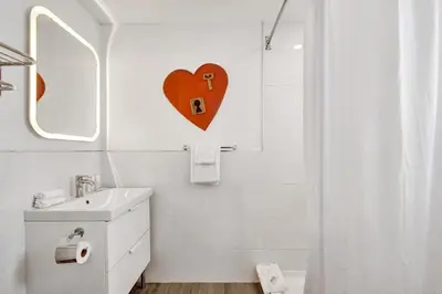 a white bathroom with a heart on the wall at Eden Escape Walk to FLT Beach 1201 in Fort Lauderdale