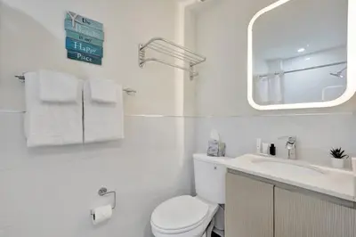 a bathroom with a toilet and a sink and a mirror at Eden Escape Walk to FLT Beach 1105 in Fort Lauderdale