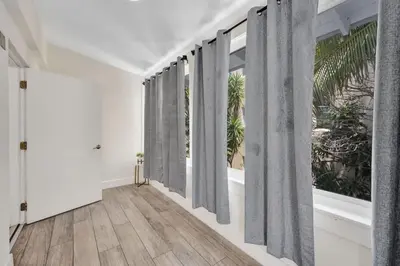 a hallway with large windows with gray curtains at Eden Escape Walk to FLT Beach 2204 in Fort Lauderdale