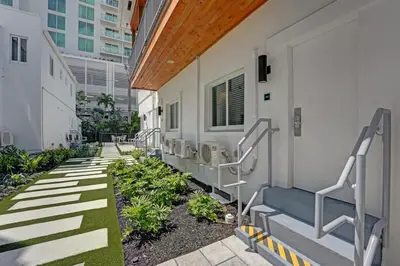 a corridor of a building with stairs and plants at Eden Escape Walk to FLT Beach 1206 in Fort Lauderdale