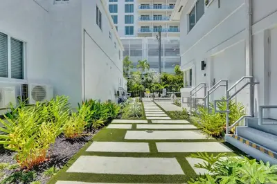 a walkway outside of a building with plants at Eden Escape Walk to FLT Beach 1206 in Fort Lauderdale