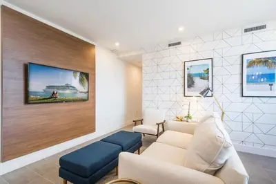 a living room with a couch and a tv on a wall at 2BR South Beach | Moderno & Aconchegante in Miami Beach
