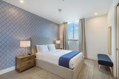 a bedroom with a bed and a blue and white wall at 2BR South Beach | Moderno & Aconchegante in Miami Beach