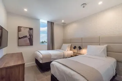 a hotel room with two beds and a window at 2BR South Beach | Moderno & Aconchegante in Miami Beach