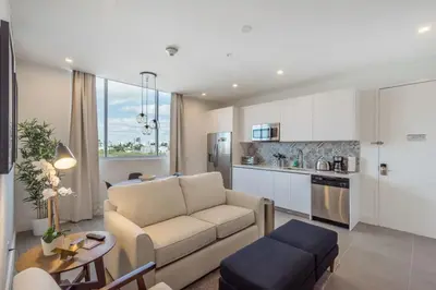 a living room with a couch and a kitchen at 2BR South Beach | Moderno & Aconchegante in Miami Beach