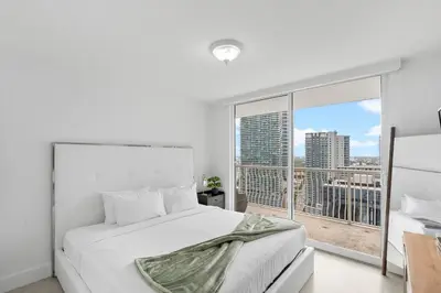 a bedroom with a white bed and a large window at Stunning 3Bedroom 34th Floor Brickell Free Parking in Miami