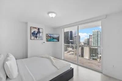 a bedroom with a bed and a large window at Stunning 3Bedroom 34th Floor Brickell Free Parking in Miami