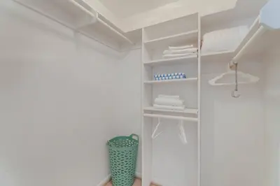 a walk in closet with white walls and white shelves at Casa de Jai- your Green Space near Brickell in Miami