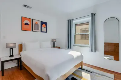 a white bedroom with a large bed and a window at Casa de Jai- your Green Space near Brickell in Miami