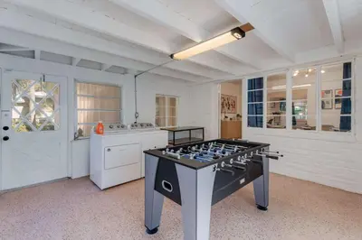 a large kitchen with a game table in the middle at Casa de Jai- your Green Space near Brickell in Miami