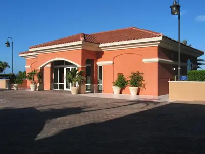a orange building with potted plants in front of it at Beautiful Mediterranean Oceanfront Condo with Private Beach in Hallandale Beach