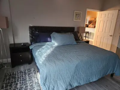 a bedroom with a bed with a blue comforter and a door at Beautiful Mediterranean Oceanfront Condo with Private Beach in Hallandale Beach