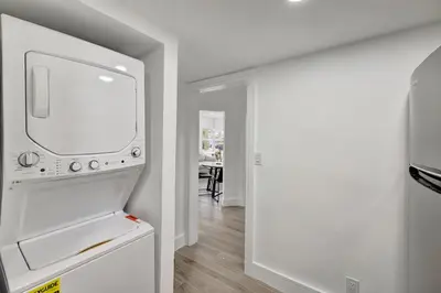 a kitchen with a white refrigerator and a table at Banyan St 2BR 1BA off Las Olas Steps to Beach 1 in Fort Lauderdale
