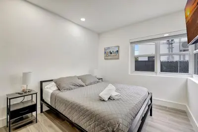 a white bedroom with a bed and a window at Banyan St 2BR 1BA off Las Olas Steps to Beach 1 in Fort Lauderdale