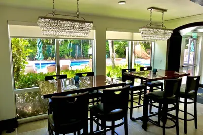 a dining room with a table and chairs and windows at Grove Cove - Pool Parking Central Coconut Grove in Miami