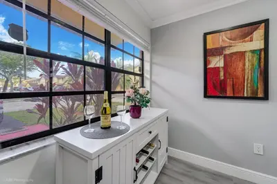 a white room with windows and a bottle of wine at Spacious 4BR Miami Townhome with Communal Pool in Ives Estates