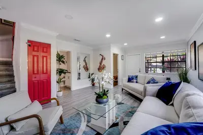 a living room with a red door and white furniture at Spacious 4BR Miami Townhome with Communal Pool in Ives Estates