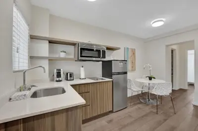 a kitchen with a sink and a refrigerator and a table at Eden Escape 1 BR 2201 Walk to FLT Beach in Fort Lauderdale