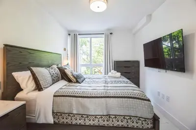a bedroom with a bed with a television on the wall at Lux 2BR City-View Retreat in Hollywood, 2nd Floor in Hollywood