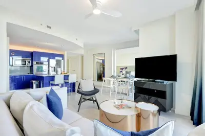 a living room with a white couch and a tv at Beach Club - Oceanfront Luxury, Resort Amenities, Balcony Views in Fort Lauderdale